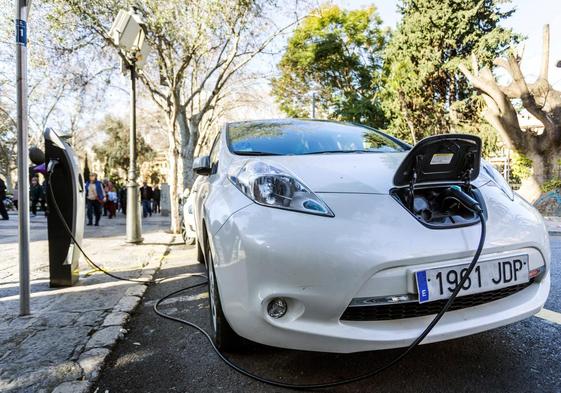 Vista de un coche eléctrico mientras carga la batería en el centro de Palma de Mallorca.