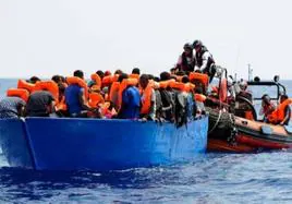 Varios inmigrantes rescatados en el mar antes de ser llevados a un barco de salvamento.