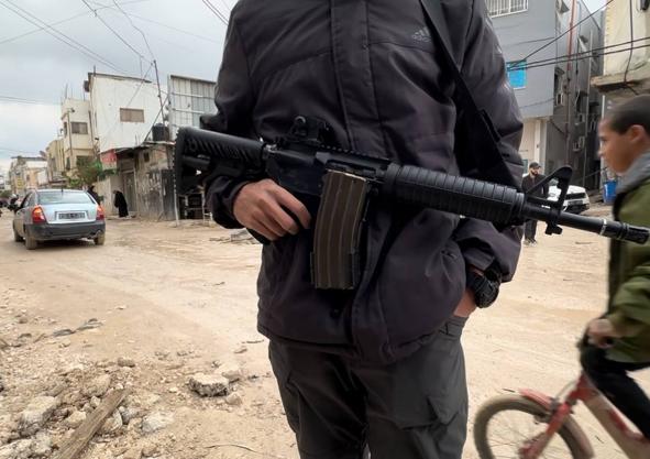 Imagen secundaria 1 - Ya no quedan calles en el campo de refugiados, sólo socavones provocados por los bombardeos. Allí los jóvenes milicianos patrullan fuertemente armados mientras las armas de fuego son protagonistas de los juegos de los niños.