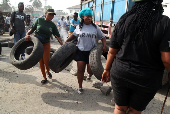 Varias manifestantes portan neumáticos con los que montaron las barricadas.