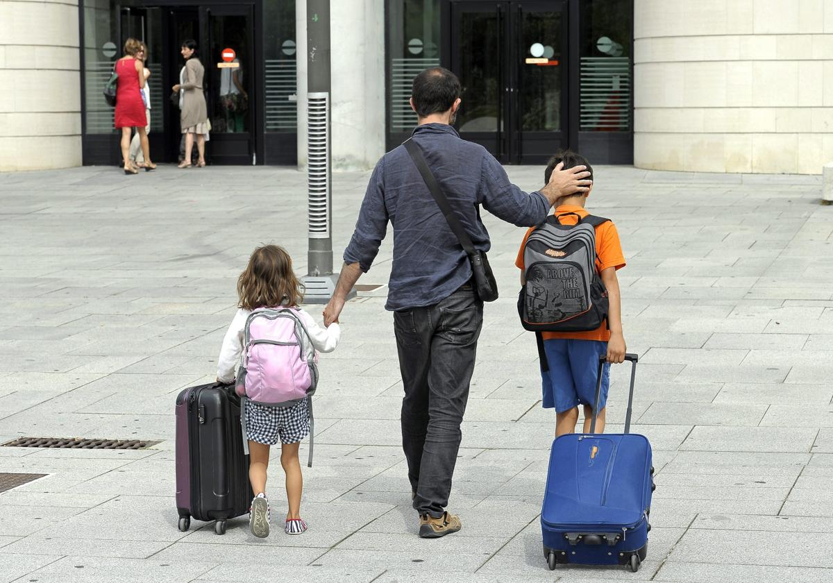 Un padre junto a sus dos hijos pequeños