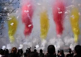 Varias personas observan el humo de colores durante la primera mascletà madrileña