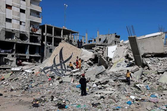 Palestinos inspeccionan las casas destruidas tras un ataque contra el campo de refugiados de Rafah..