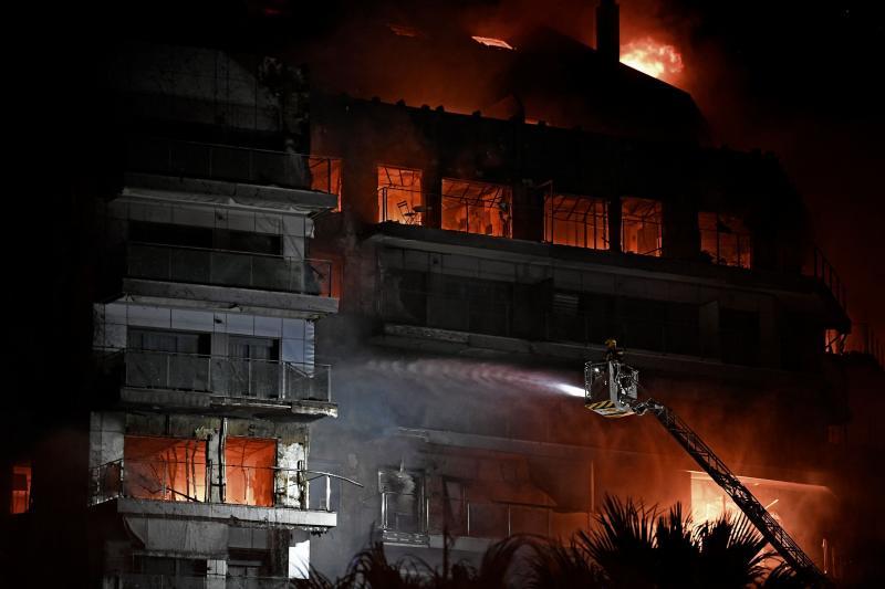 Un bombero intenta apagar las llamas tras más de tres horas de incendio.