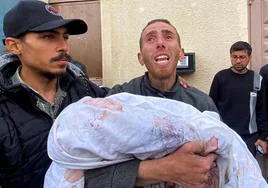Ahmed Azam lleva el cuerpo de su hijo Muhanad, que murió en un ataque israelí, al hospital Al Aqsa de Gaza.