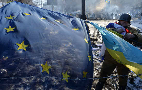 Manifestante con la bandera europea y la bandera ucraniana, en las barricadas en Kiev