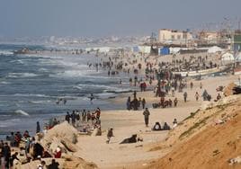 Ciudadanos gazatíes, en una de las playas donde cayó la ayuda humanitaria lanzada por la aviación egipcia.