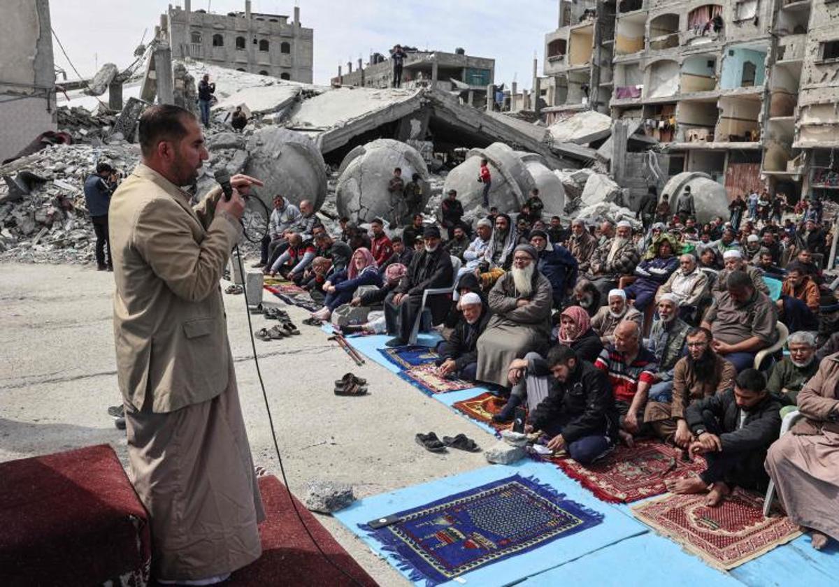 Decenas de palestinos atienden entre los restos de una mezquita bombardeada, un día después de la masacre en Al-Rashid.