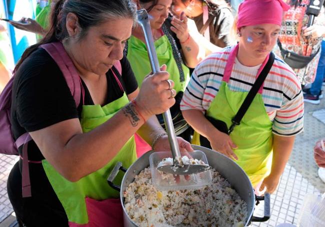 Una voluntaria sirve comida a manifestantes que exigen a Milei ayuda para lo más necesitados.