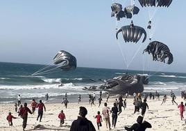 Algunos de los envíos cayeron sobre el mar. En la imagen se ve cómo gazatíes corren para recoger las cajas de ayuda humanitaria.