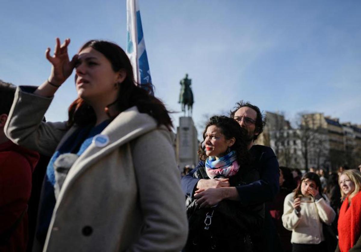 Varias personas siguen la histórica sesión en una pantalla gigante.