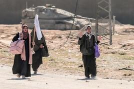 Mujeres palestinas cargan con sus pertenencias en la ciudad de Hamad.