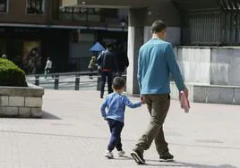 Un padre con su hijo de la mano tras recogerle del colegio.