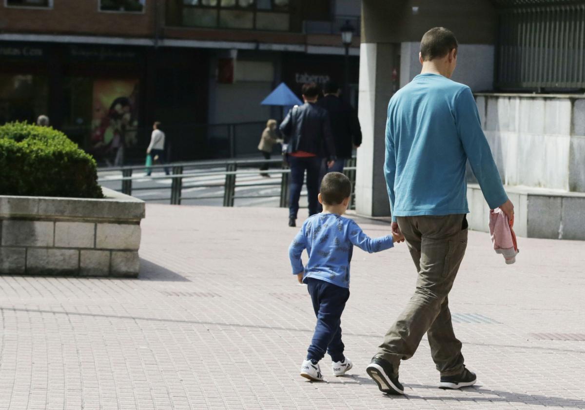 Un padre con su hijo de la mano tras recogerle del colegio.