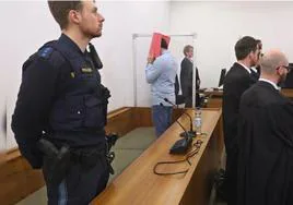 El acusado oculta su rostro durante el juicio.