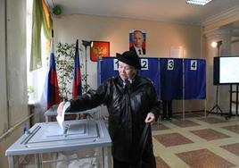 Una mujer deposita su voto en un colegio lectoral de la ocupada Donetsk.