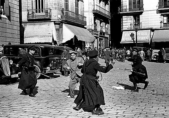 Un manifestante es golpeado por guardias de asalto republicanos durante unos disturbios en la Plaza de Sant Jaume, Barcelona.
