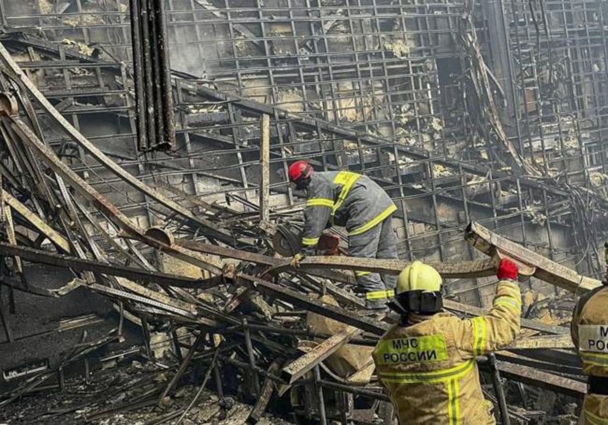 Los equipos de bomberos trabajan en el edificio incendiado.