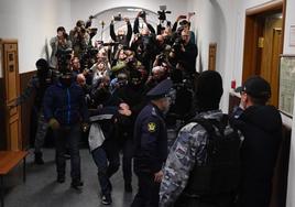 Agentes trasladan a un tribunal de Moscú a uno de los sospechosos de la matanza.