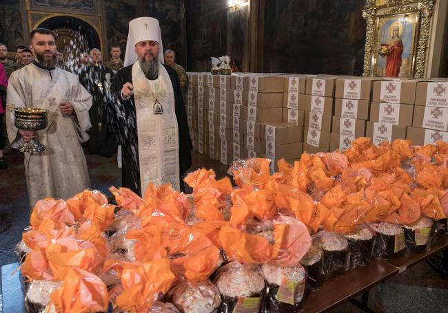 El jefe de la Iglesia Ortodoxa ucraniana rocía agua bendita sobre pasteles de Pascua que serán transferidos a los militares que luchan en el frente.