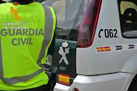 Un agente de la Guardia Civil junto a uno de sus coches