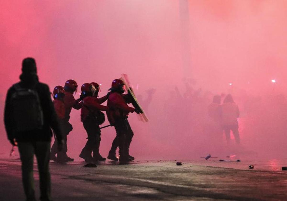 Agentes de la Ertzaintza se protegen ante el lanzamiento de objetos en la entrada de San Mamés.