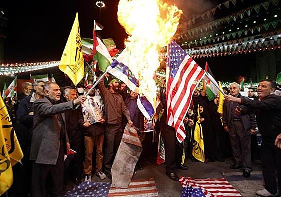 Manifestantes iraníes queman banderas de Israel y Estados Unidos en Teherán.