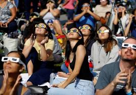 Un grupo de jóvenes observa el eclipse solar en el Observatorio Griffith en Los Ángeles, California.