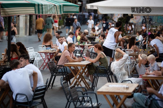 Varias personas sentadas en terrazas en la plaza dels Àngels del Raval, en Barcelona