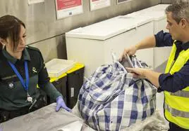 Dos agentes revisan el equipaje sospechoso de un pasajero en el aeropuerto de Madrid-Barajas.