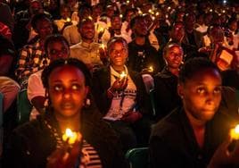 Jóvenes ruandeses sostienen velas sin durante una vigilia por el 30 aniversario del genocidio de Ruanda.