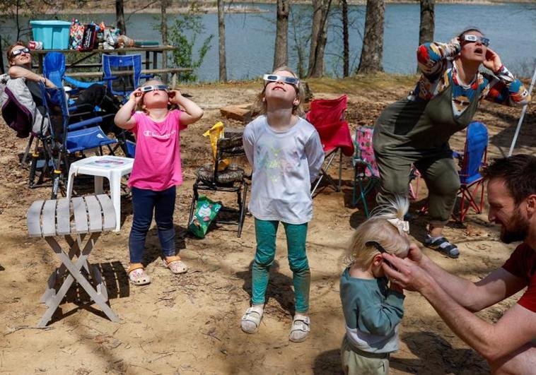 Una familia se coloca gafas para ver eclipses en la localidad de Makanda, en Illinois.