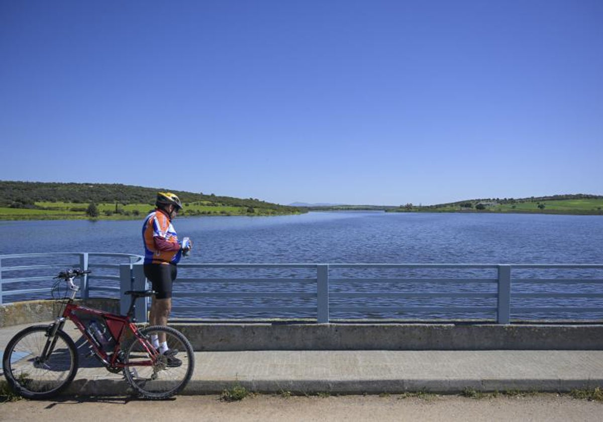 Un ciclista parado junto al embalse de El Vicario (Ciudad Real) que roza el 85% de su capacidad.