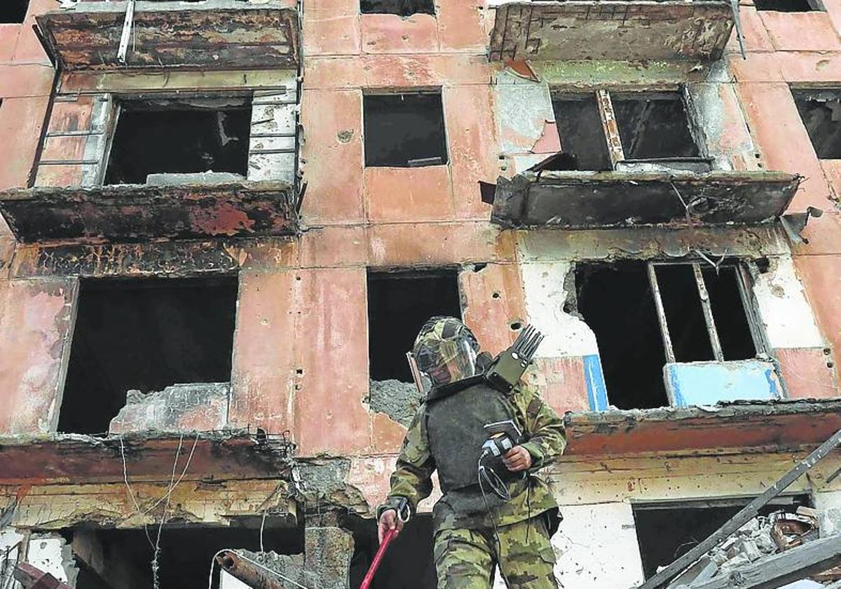 Un soldado examina unas ruinas en la ciudad de Mariupol.