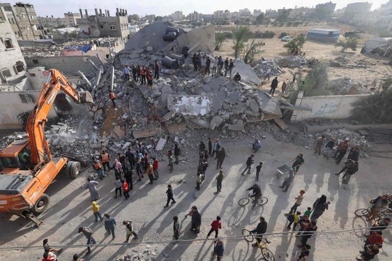 Los gazatíes se reúnen junto a las ruinas de uno de los tres edificios bombardeados en Rafah.