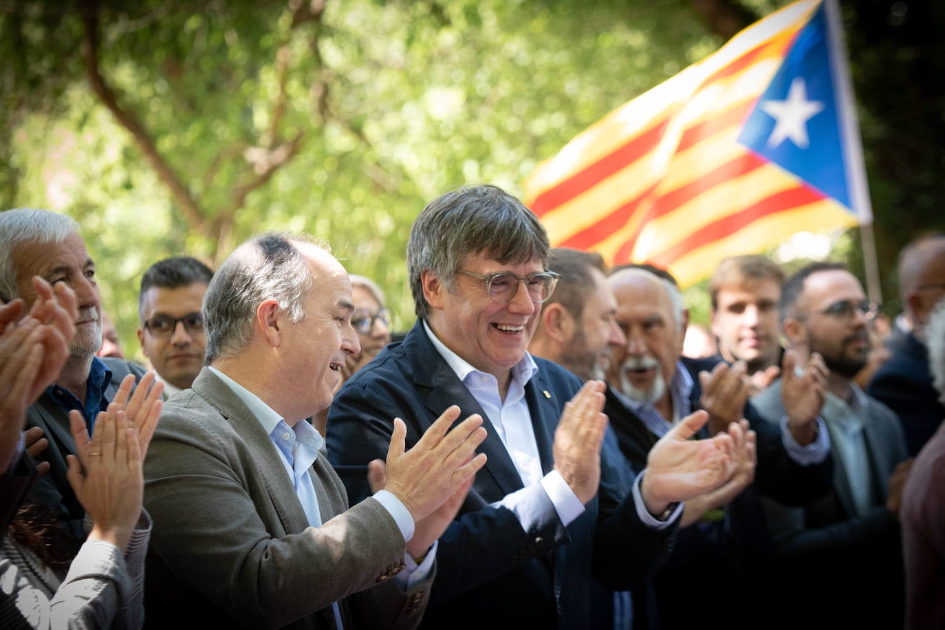 Puigdemont aplaude ayer junto a Jordi Turull en el acto de Junts en el sur de Francia.