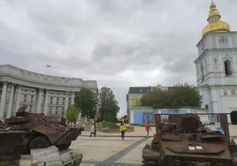 Vecinos de Kiev caminan junto a tanques y vehículos de combate rusos calcinados expuestos en la plaza de San Miguel.
