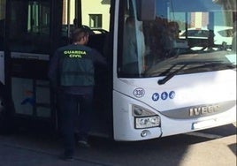 Un guardia civil inspecciona un autobús urbano.