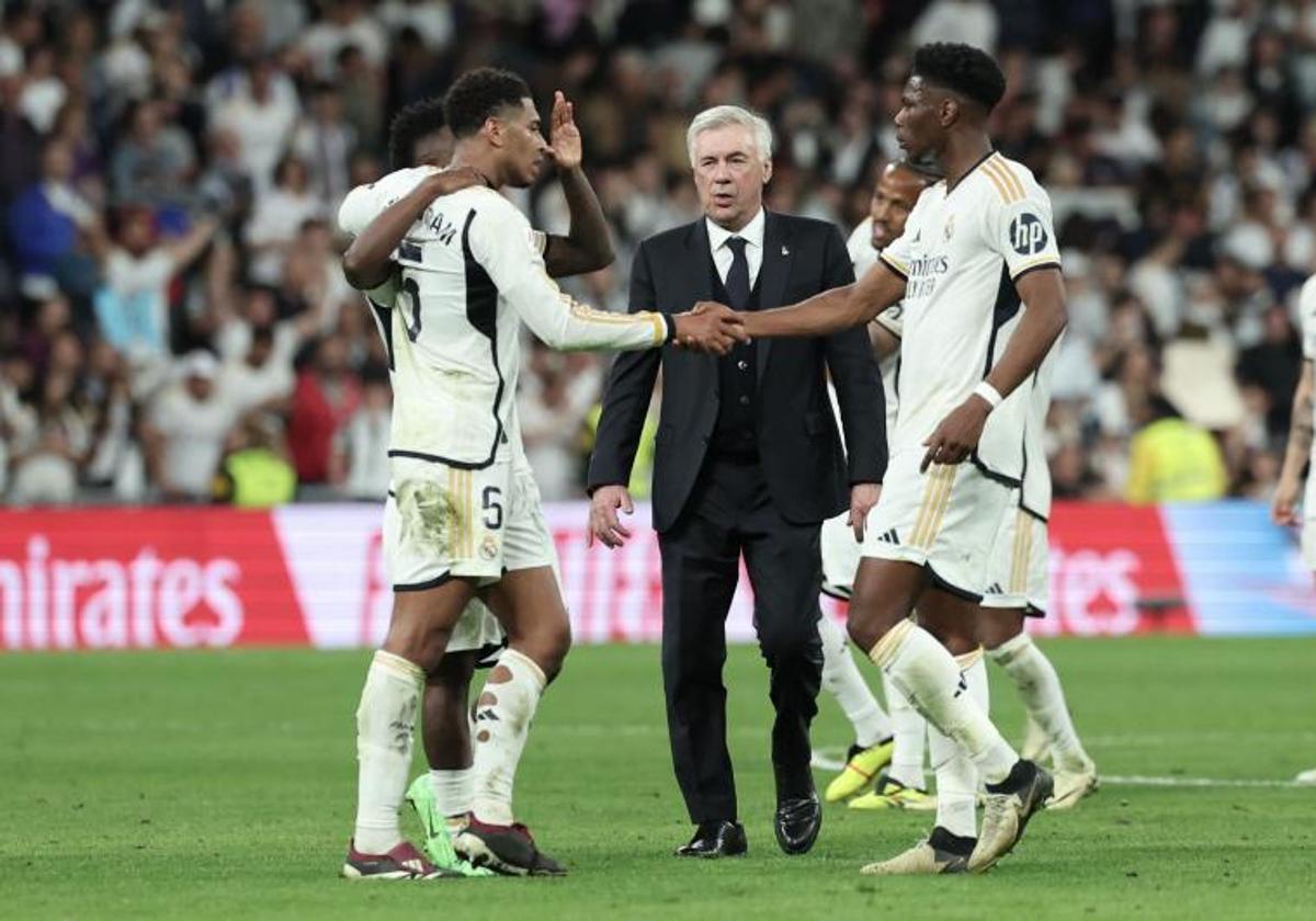 Los jugadores del Real Madrid se felicitan por la victoria en el clásico en presencia de Ancelotti.