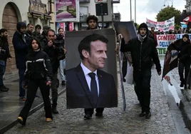 Un grupo de jóvenes manifestantes porta una imagen de Emmanuel Macron durante una marcha ecologista.