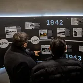 Visitantes al nuevo museo observan un panel histórico sobre la represión nazi.