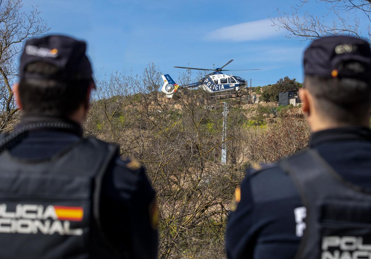 Dos agentes de la Policía Nacional observan el vuelo de un helicóptero