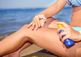 Una mujer se aplica crema protectora solar.