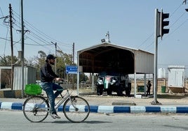 Un refugiado sirio pasa en bicicleta ante la tanqueta blindada del ejército que vigila la entrada al campo de refugiados de Zaatari.