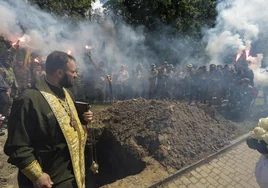 Los camaradas queman bengalas durante la ceremonia funeraria de un militar ucraniano.