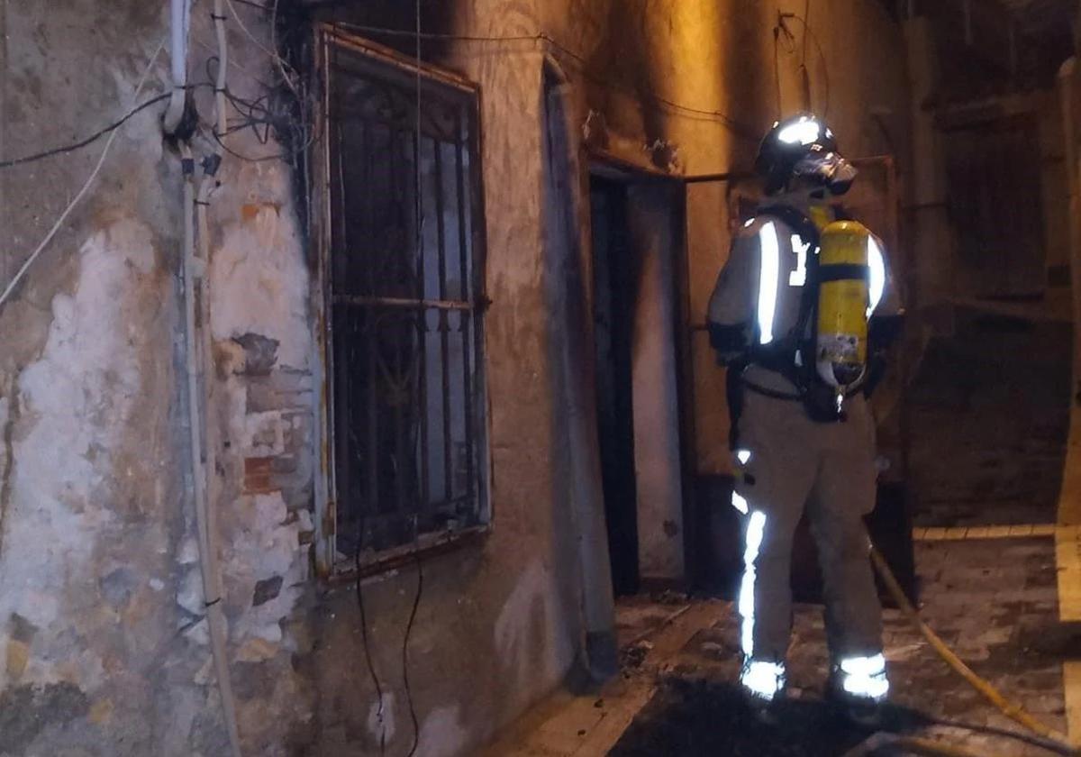 Un bombero trabaja en el incendio de la vivienda en el municipio de Ricote