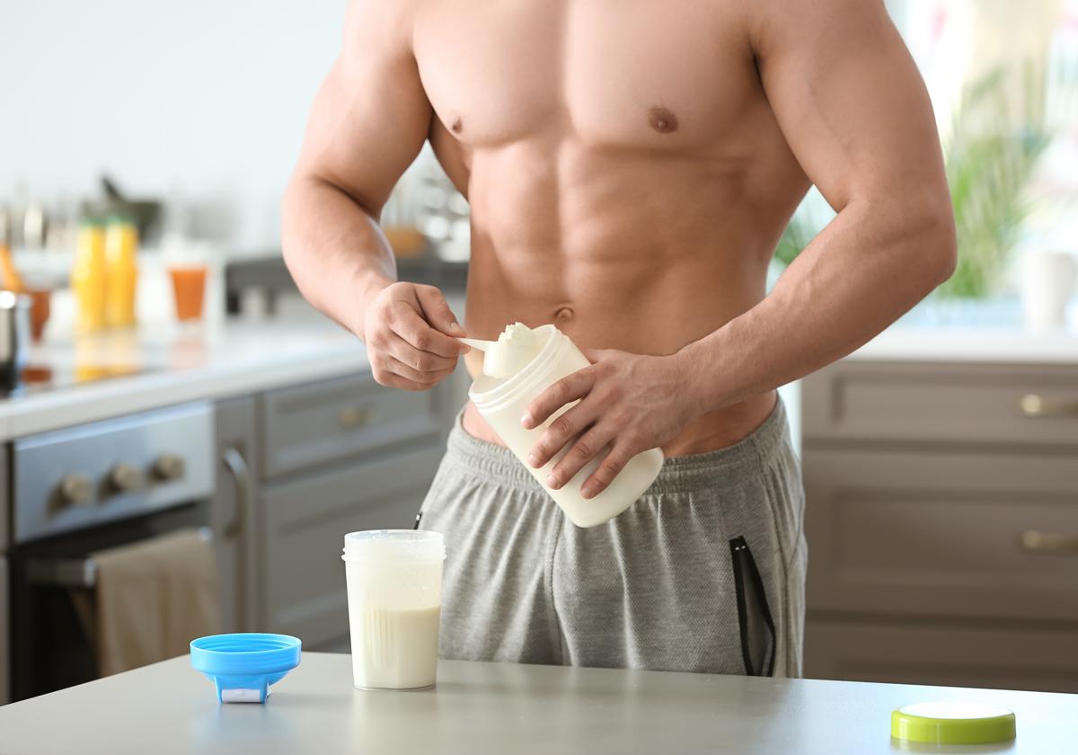 Un hombre prepara un batido de proteínas para ganar músculo.