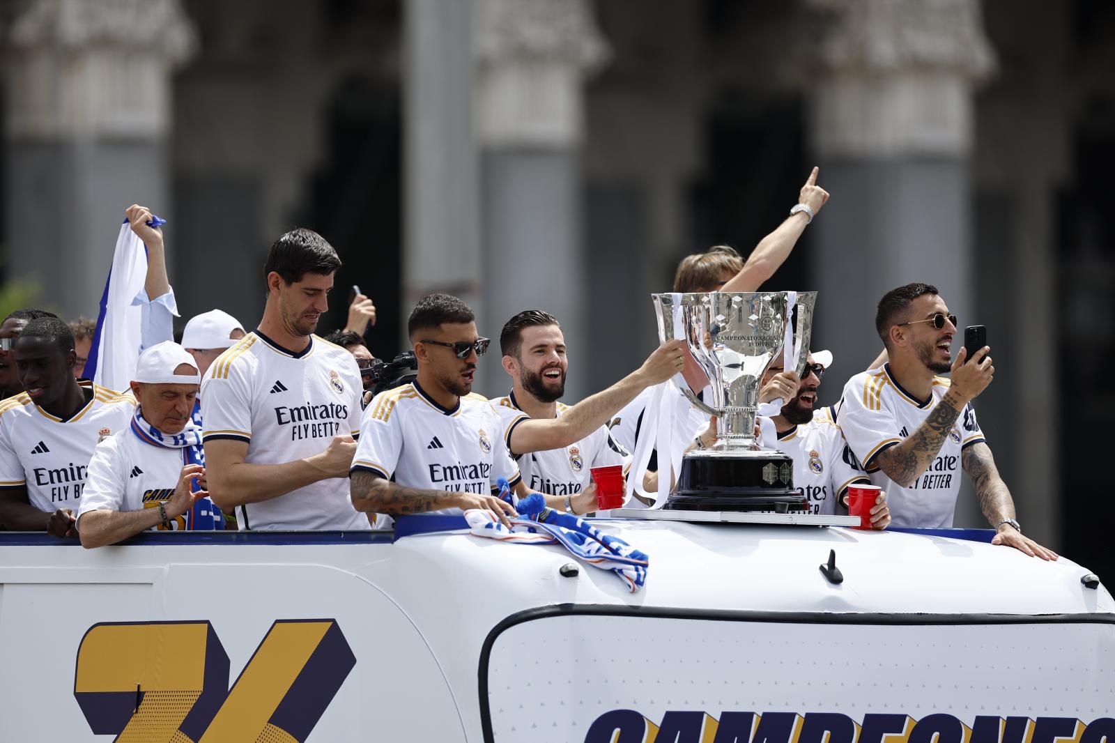 Los jugadores del Real Madrid saludan desde el autobús a los aficionados en la Plaza de Cibeles 