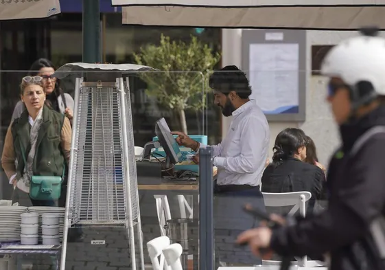 Un camarero trabajando en la terraza de un restaurante.