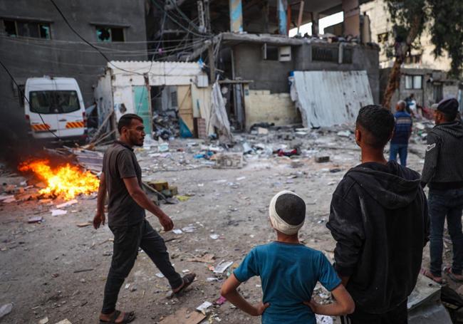 Un grupo de palestinos observa los restos de una vivienda bombardeada por Israel en Rafah, en el sur de Gaza.